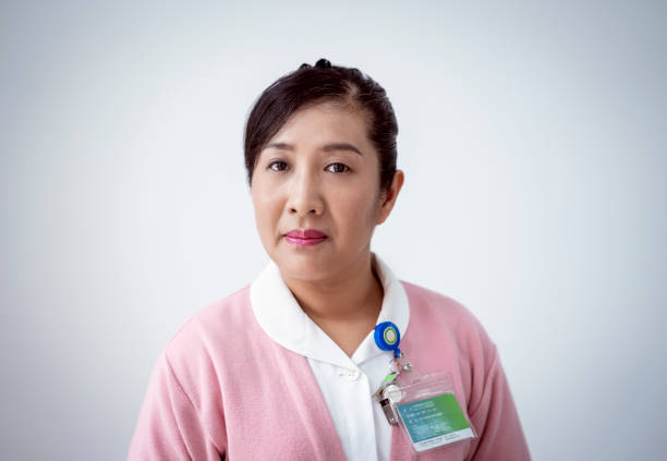 Portrait of mature nurse against white background Portrait of mature nurse against white background. Female healthcare worker is with confident look on her face. She is wearing uniform with badge. taiwan photos stock pictures, royalty-free photos & images