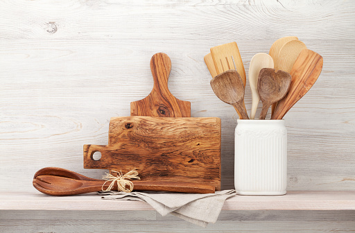 Set of various kitchen utensils. In front of wooden wall with copy space for your text