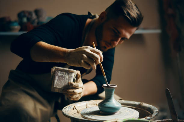 istock Man painting handmade pottery at ceramic workshop 1152196554