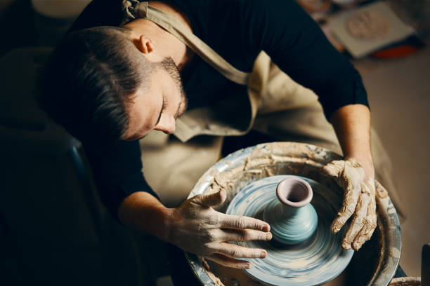 Potter modeling ceramic pot from clay on a potter's wheel Potter modeling ceramic pot from clay on a potter's wheel. Workshop, art concept artist sculptor stock pictures, royalty-free photos & images
