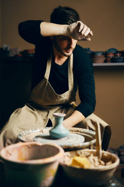istock Tired potter modeling ceramic pot on a potter's wheel 1152196572