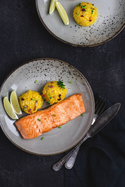 istock Grilled Salmon Fillets with Saffron Risotto and Lime on Dark Background 1152197333
