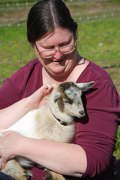istock Woman Holding Baby Pygmy Goat 115220051