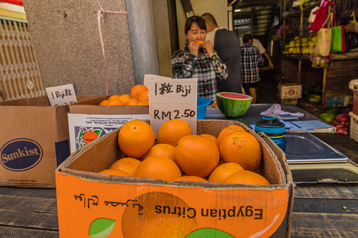 George Town, Penang Island, Malaysia. March 8 2019. A market stall selling oranges at Campbell street fruit and Vegetable market in George Town Malaysia. Campbell Street Market is within George Town's UNESCO World Heritage Site and was built in the 1900s, the Victorian-style market is located at the junction between Campbell Street and Carnavon Street.