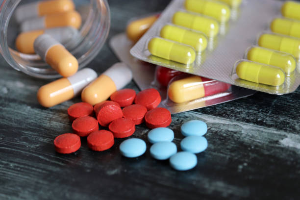 알 약 및 캡슐에 물집 팩과 병 어두운 나무 테이블에, 다른 종류의 약물 클로즈업 - capsule pharmacy addiction antibiotic 뉴스 사진 이미지