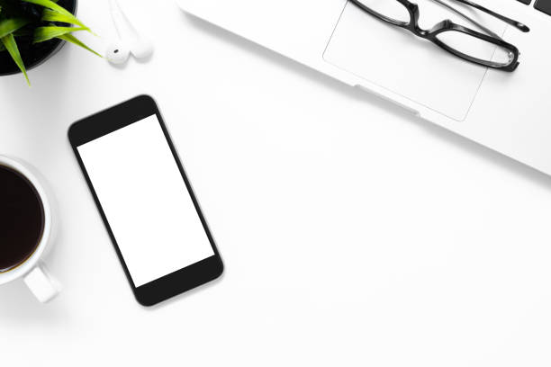 istock White office desk table with smartphone with blank screen and other office supplies. Top view with copy space, flat lay. 1152205252