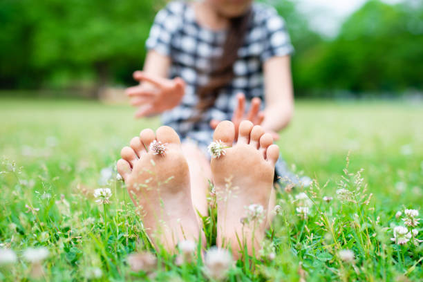 Young Child Plays Barefoot In The Grass and Dirt