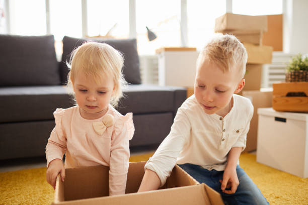 istock Kids unpacking box in new flat 1152205820