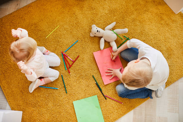 istock Kids drawing on paper while sitting on floor 1152205841