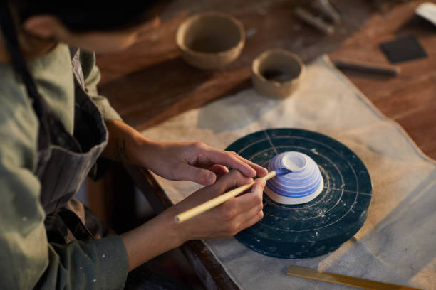 istock Potter painting ceramic bowl 1152208040