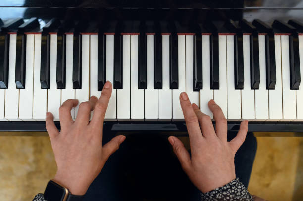 istock Young woman is practicing with playing the piano keyboard 1152209980