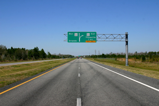 Toronto, Canada - August 23, 2023: Traffic heads west on Highway 401 near Exit 373 to Leslie Street. Overcast skies in the Henry Farm neighborhood north of Highway 401. Upscale residential buildings line the Bayview Village neighborhood in the background.