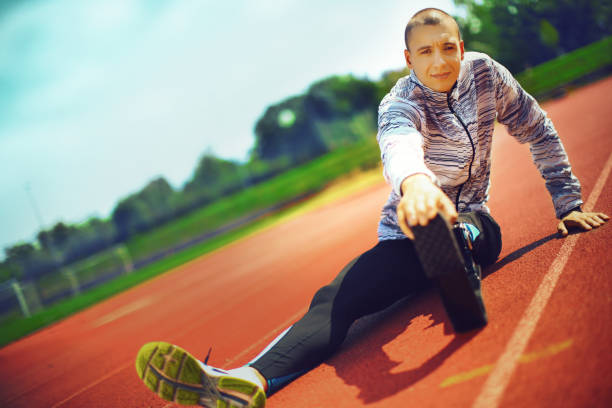 istock Young athlete stretching at track stadium. 1152210765