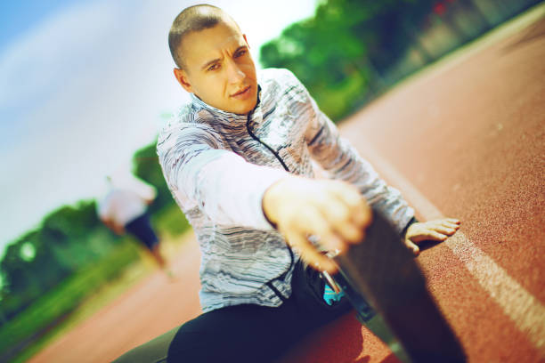 istock Young athlete stretching at track stadium. 1152211029