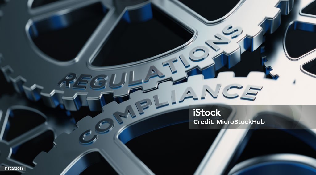 Metal Cogs With Regulations And Compliance Text - Compliance Concept Metal cogs are turning. Regulations and compliance words are written on the cogs. Horizontal composition with copy space. Obedience Stock Photo