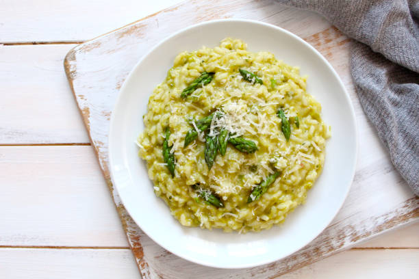 Italian risotto with asparagus and parmesan cheese on light background. stock photo