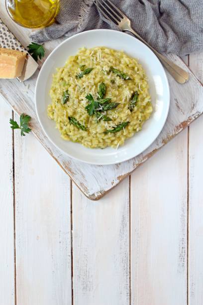Italian risotto with asparagus and parmesan cheese on light background. stock photo