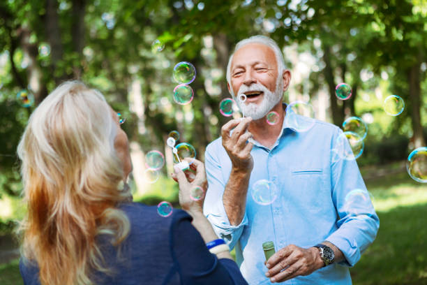 Elderly couple enjoying themselves blowing bubbles