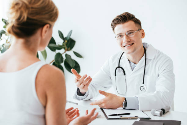 istock selective focus of cheerful doctor in glasses and white coat gesturing while looking patient 1152216899