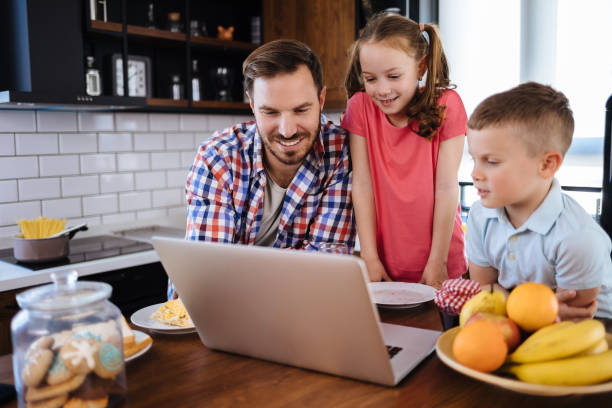 istock Father and children using laptop together during breakfast 1152218964
