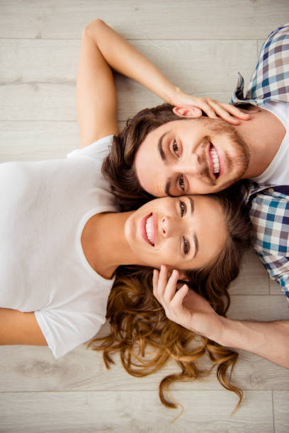 istock Vertical top above high angle view photo pair beautiful he him his macho she her lady just married enjoy honeymoon loneliness overjoyed lying close faces in love apartments flat bright room indoors 1152219862