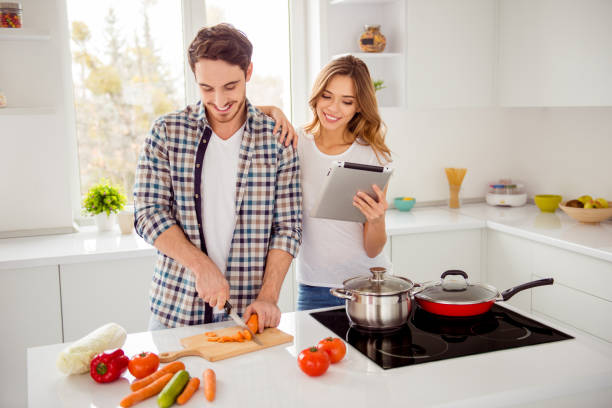 istock Close up photo pair beautiful he him his macho she her lady e-book e-reader electronic cook book overjoyed making first vegan breakfast dishes bonding apartments flat bright kitchen room indoors 1152220454