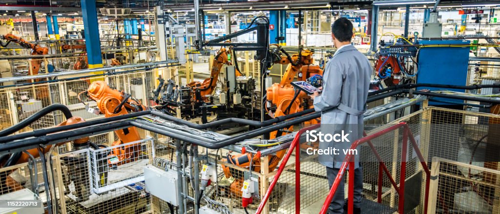 Ingeniero que supervisa el proceso de producción automatizado en una fábrica - Foto de stock de Manufacturar libre de derechos
