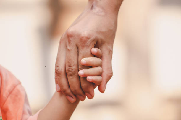 istock Mother holding a child's hand on blurred bokeh background. 1152220766