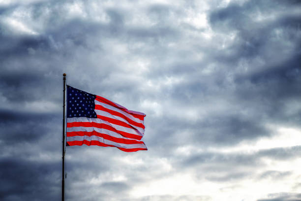 istock American flag flapping in dark ominous sky 1152226360