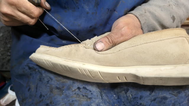 Shoe maker is repairing shoe