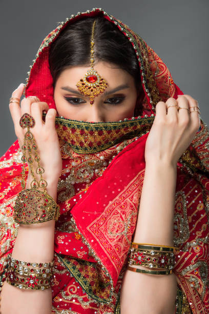 istock attractive indian woman with bindi closing face, isolated on grey 1152228583