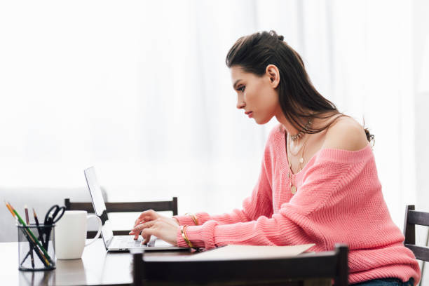 istock beautiful indian woman using laptop at table at home 1152229446