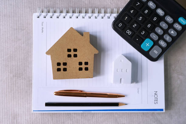 istock Topview housing models and pen and calculator decorate on planning book. 1152231522