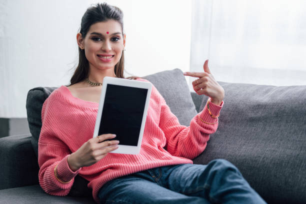 istock happy indian woman with bindi pointing at digital tablet with blank screen 1152233660