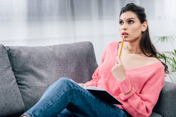 istock female indian student thinking and writing in notebook 1152233828