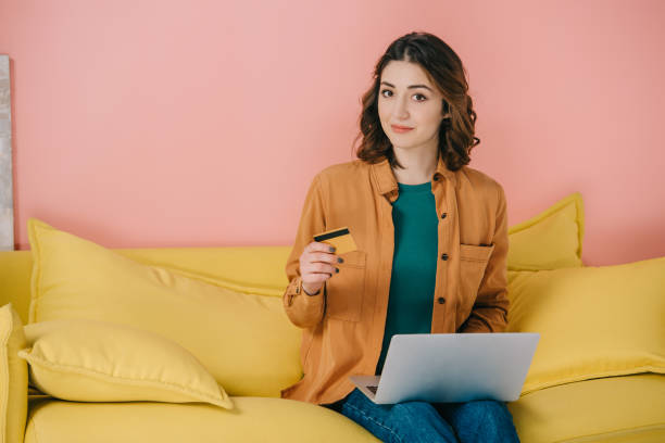 istock attractive woman  holding credit card while using laptop 1152235376
