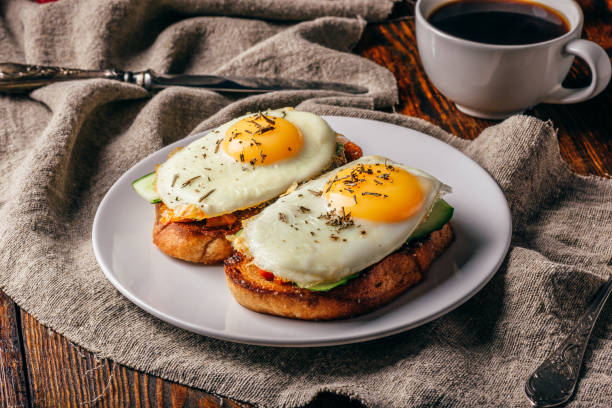 Toasts with vegetables and fried eggs with cup of coffee