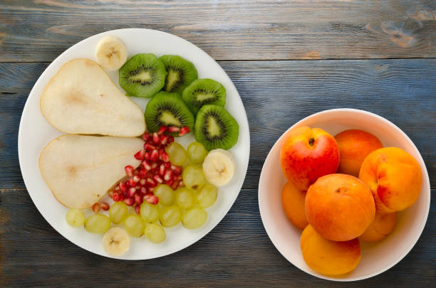 istock fruit mix (pear, kiwi, grapes, banana, pomegranate) on a wooden background 1152237243