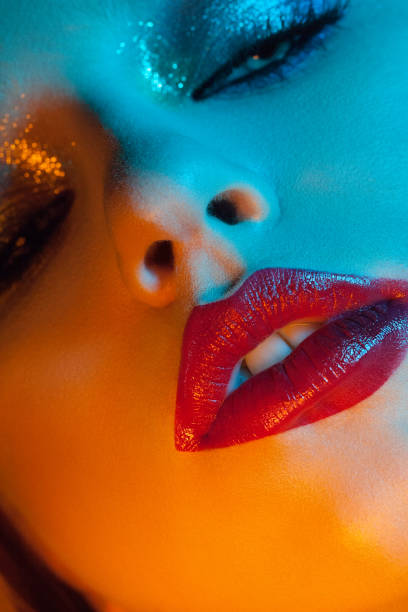 istock pretty girl with red lips and blue light on the face 1152238227