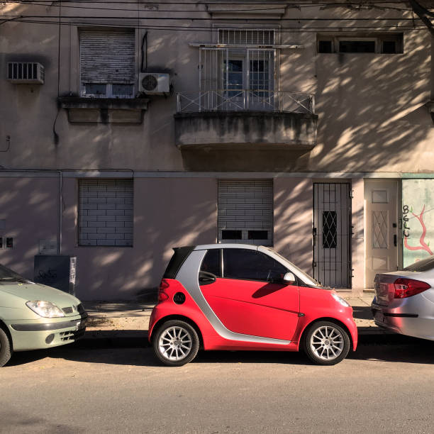 Little red car parked in the street Buenos Aires, Argentina - May 24, 2019: Little Mercedes Benz Smart model showing its space saving capabilities as it can park with only a few space between cars. In this city the traffic and parking spaces are a significant problem and this car seems to be a solution for it mercedes argentina stock pictures, royalty-free photos & images