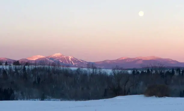 Early morning sunrise on Jay Peak as moon is setting.