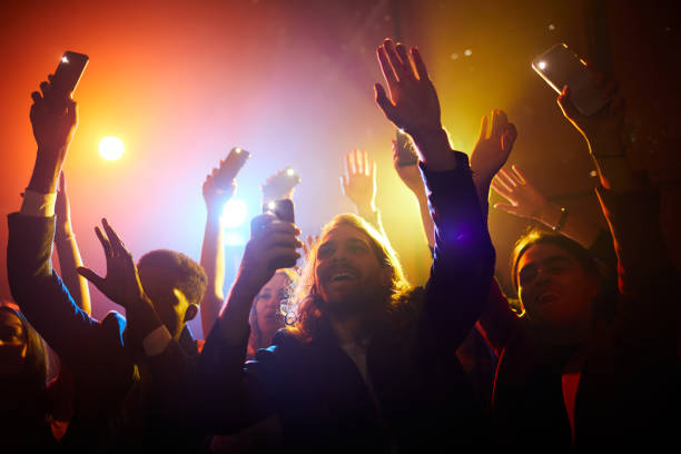 istock Excited fans waving gadgets with flashlights turned on 1152246023
