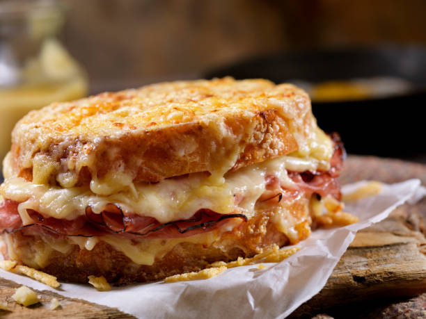 croque monsieur, grilled cheese sandwich with black forest ham, gruyere and bechamel sauce - hollandaise sauce imagens e fotografias de stock