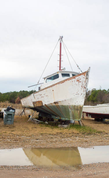 istock Old boat in marina shipyeard awaiting repairs against a cloudy sky 1152247236