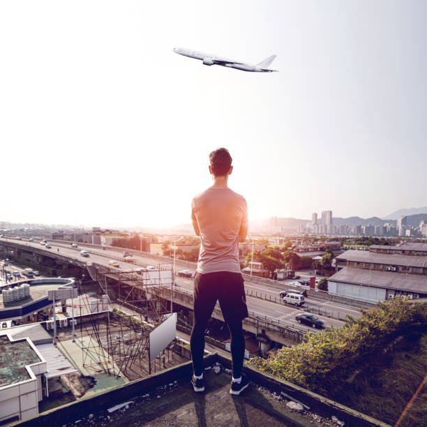 istock Man looking at view and an airplane taking off 1152249584