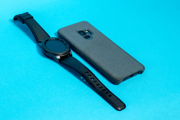 istock Smartphone in a gray textile case and a smart watch on a blue background 1152250679