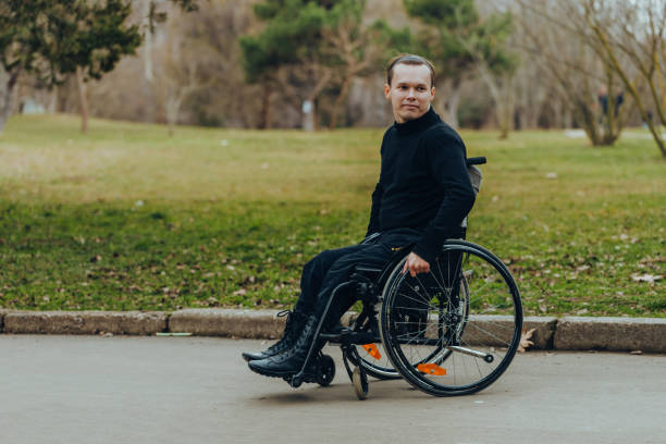 istock young disabled man in wheelchair walking park 1152253058