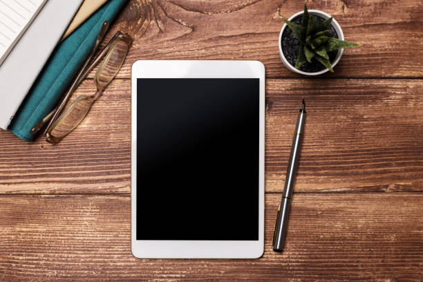istock White digital tablet on wooden table. Flat lay. 1152253406