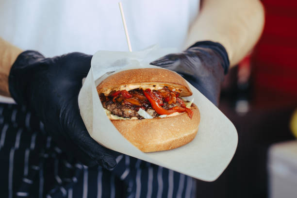 istock Cook preparing burger adding the sauce on the cream cheese. Three burgers. 1152253581