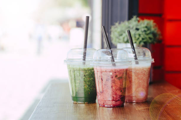 istock Sweet smoothie in plastic cups on wooden table 1152253593